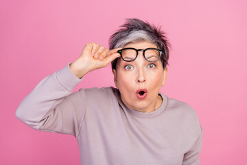 Photo of anxious embarrassed impressed woman open mouth hold glasses wow reaction isolated on pink...