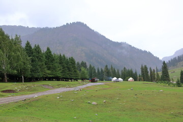 landscape near Jeti Oguz gorge with yurts and green meadows on a cloudy day