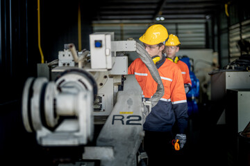 male engineer workers maintenance automatic robotic arm machine in a factory. worker checking and...