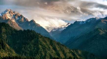 Beautiful panorama of mountains with snowy peaks and glaciers on a summer evening.