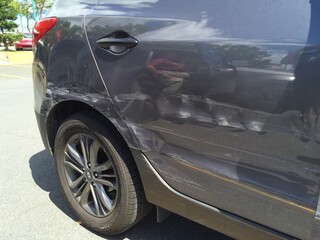 Accident Damage on Side of Gray Car in Parking Lot