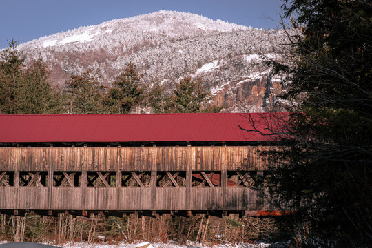 Albany covered bridge in NH White Mountain National Forest over the Swift River with snow covered mountains in background