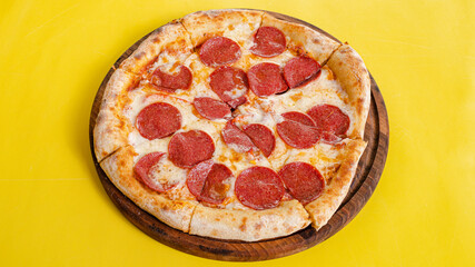 Pizza pepproni top view isolated on yellow background