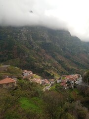 Fototapeta na wymiar Little village between cloudy mountains