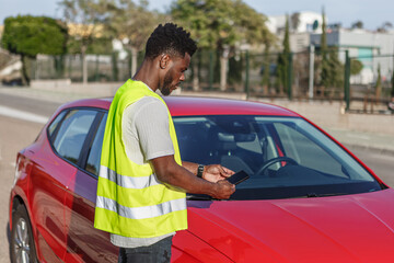 Man Standing Next to Red Car Using Cell Phone