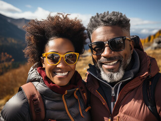 Smiling black couple in outdoor gear hike together in some mountains
