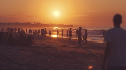 An unfocused group of people gathered on the beach during a vibrant sunset, capturing the essence of summer evenings.