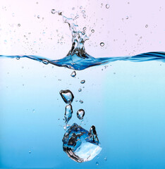 Ice cube splashing in the light blue water