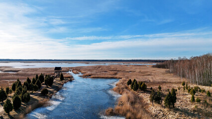 Wooden Bords Trail Through the Kaniera Lake Reeds Aerial Spring Shot Lapmezciems, Latvia. Frozen Lake and Baltic Sea in the Background. Early Spring in Latvia, Kemeri National Park. Slow Motion Shot