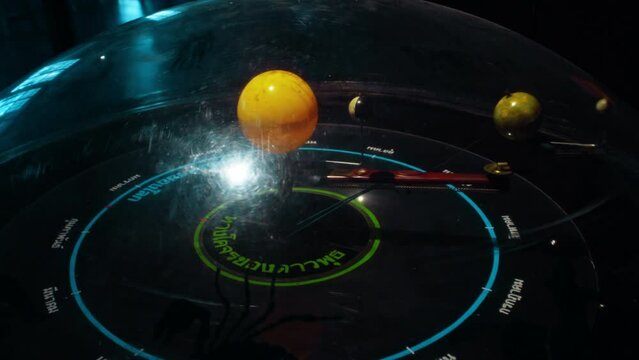 A mechanical model of a solar system with moving objects standing in a dark room