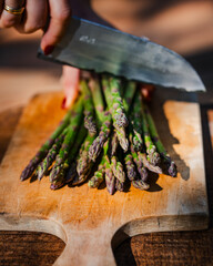 Fresh Spears on a Wooden Board with a Knife