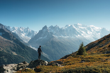 Male traveler standing with enjoying the Mont Blanc massif during trail among the French Alps at...