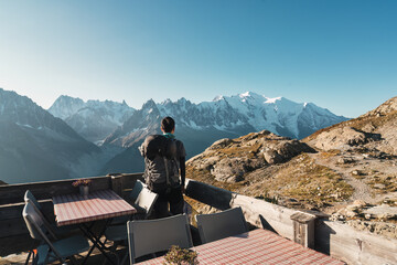 Male backpacker enjoying the view Mont Blanc massif on balcony in French Alps at France