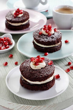Mini chocolate cakes with cream and pomegranate seeds