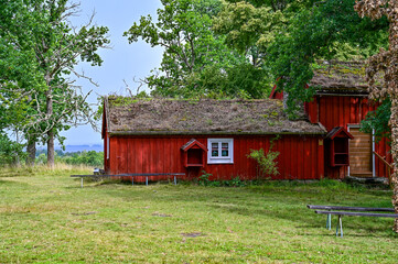 typical, traditional red Swedish house, wooden house with a mossy roof in Hembygdsgard Lunnabacken, a historic homestead near Ugglekull, Urshult, Smaland Sweden