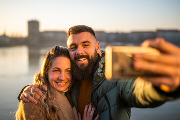 Close up image of happy couple taking selfie outdoor.	