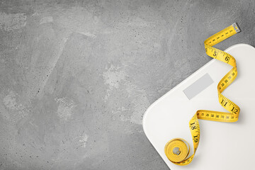 scales and measuring tape on a gray background. diet and weight loss concept