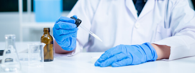 Fototapeta premium Nutritionist or scientist dripping dairy milk to checking the quality and temperature. Concept of nutrition, lactose, protein, bacteria, fat and glucose laboratory. Dairy milk test and research.