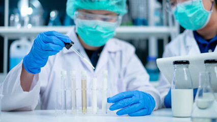 Nutritionist or scientist dripping dairy milk to checking the quality and temperature. Concept of nutrition, lactose, protein, bacteria, fat and glucose laboratory. Dairy milk test and research. © Irin