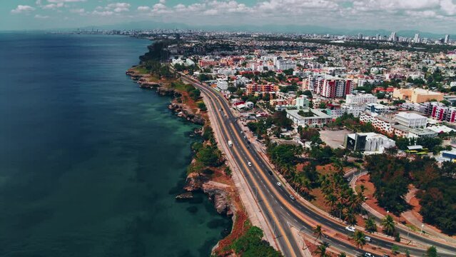 Aerial view of a scenic road in the Dominican Republic on the Caribbean coast. View of the highway on the coast on the way to summer vacation. Cityscape in the soft sunset light.