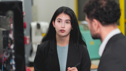 A Professional female engineer and Male CEO are working on PLC Control panel CNC machine. Expertise and technician repairman is maintenance, programming, and improve the automatic innovation machinery