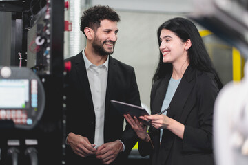 A Professional female engineer and Male CEO are working on PLC Control panel CNC machine. Expertise and technician repairman is maintenance, programming, and improve the automatic innovation machinery