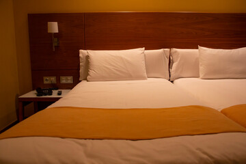 Beds in a hotel, where you can see how they are made as well as the headboard and the night lamps. Concept: rest, sleep