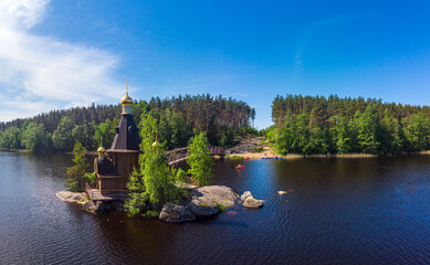 Aerial top view to wooden Church of St. Apostle Andrew First-Called on Vuoksa River with bridge....