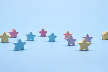Multicolor wooden stars shapes symbol label form isolated on the bright solid fond plain bright...