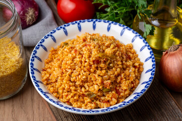 Traditional turkish bulgur pilaf with tomato sause in plate (Turkish name; meyhane pilavi)
