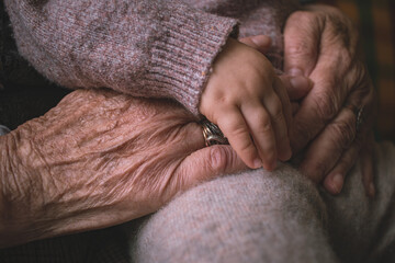 grandmother holds baby's hands