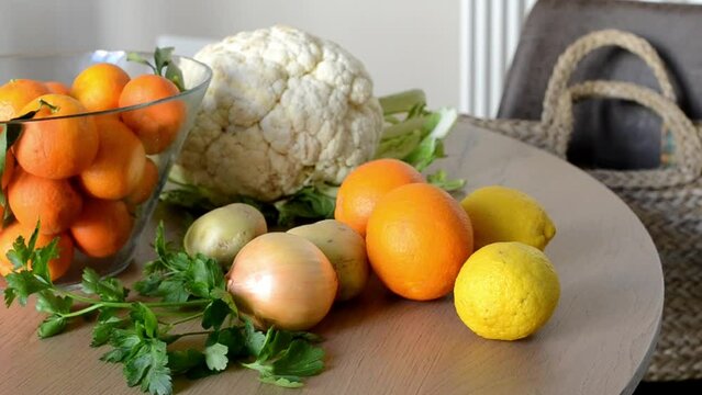 A Female Person takes Vegetables from a Straw Bag and Places them on the Table. Close-up Kitchen Scene. Organic Fresh Food. Living Close to Nature, Farming. Fruits and Vegetables. Nutrition, Diet.