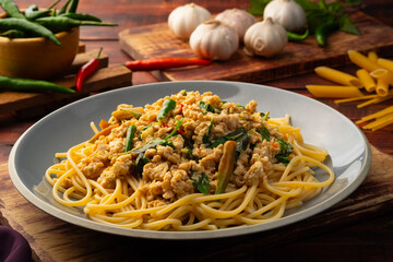 Stir fried spicy spaghetti with minced chicken breast and basil leaves in white plate,Spicy pasta...