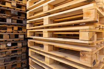 Piles of stacked natural wooden shipping pallets.