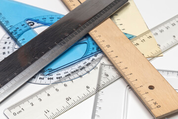 Various rulers of different shapes on white background
