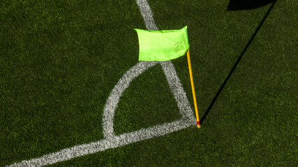 Close up of the corner flag of a football pitch with artificial grass.