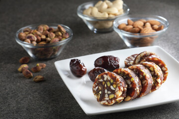 Healthy snacks, fitness lifestyle and high fiber diet concept with dates and dryfruits energy bars surrounded by dried fruits, Cashew Nuts, pistachios , almonds