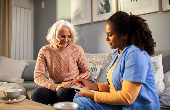 Senior woman talking to caregiver at home