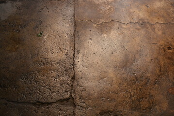 Building materials, wet concrete asphalt old after a rainstorm very bright brown background.