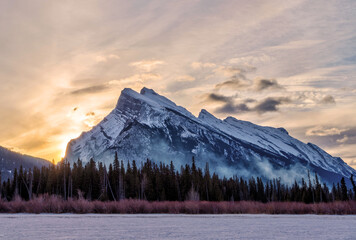 Winter sunrise over frozen Vermilion Lakes covered in snow at Banff National Park