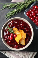 Fresh cranberry sauce, rosemary, orange peel and berries on table, top view