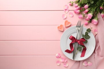 Place setting with heart shaped candles and bouquet of roses for romantic dinner on pink wooden table, flat lay. Space for text