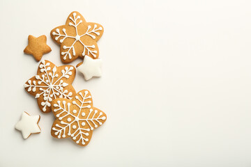 Tasty Christmas cookies with icing on white background, flat lay. Space for text