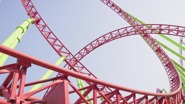 Roller coaster Ride against blue sky. Roller coaster in the amusement park. Cheerful entertainments in park of attractions