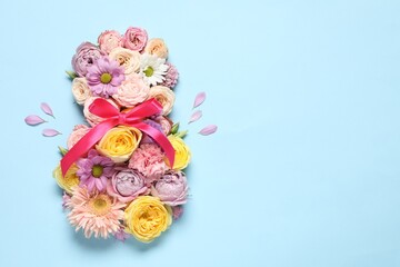 8 March greeting card design made with beautiful flowers on light blue background, top view. Space for text