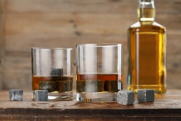 Obraz na płótnie Canvas Whiskey stones and drink on wooden table, closeup