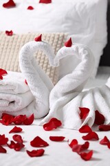 Honeymoon. Swans made with towels and beautiful rose petals on bed