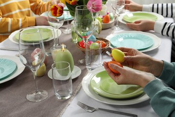 Festive table setting. Women celebrating Easter at home, closeup