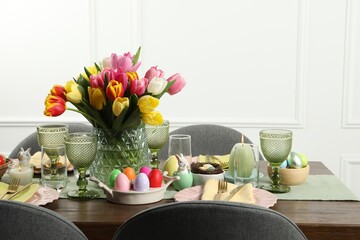 Easter celebration. Festive table setting with beautiful flowers and painted eggs