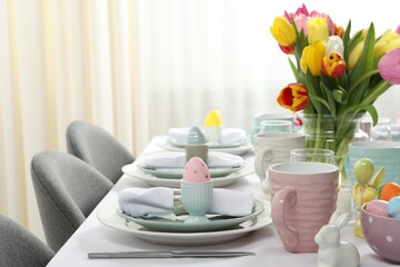 Easter celebration. Festive table setting with beautiful flowers and painted eggs